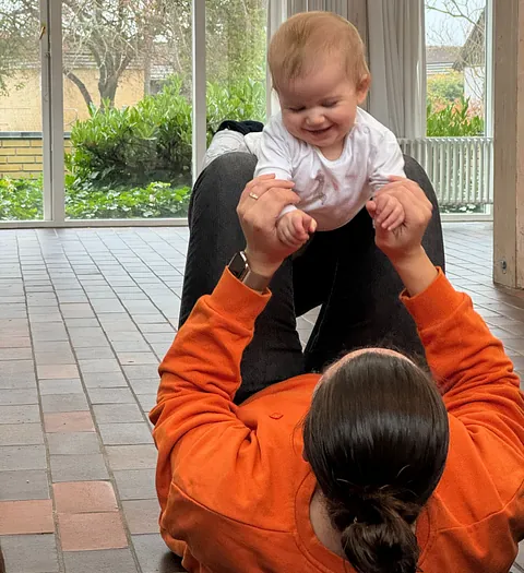 baby og mor leger på gulvet til babysalmesang